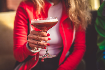 A girl holding a cocktail in her hand