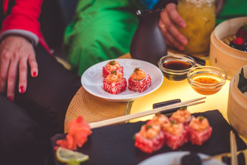 Cocktail, sushi and Japanese food on the table