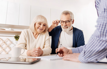 Creative agent showing house layout to aged couple of clients
