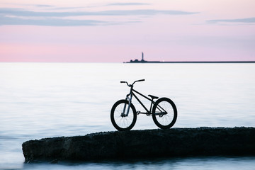 Long exposure shot of Freestyle mountain bike on a rock in the sea