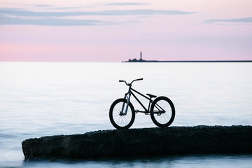 Fototapeta premium Long exposure shot of Freestyle mountain bike on a rock in the sea