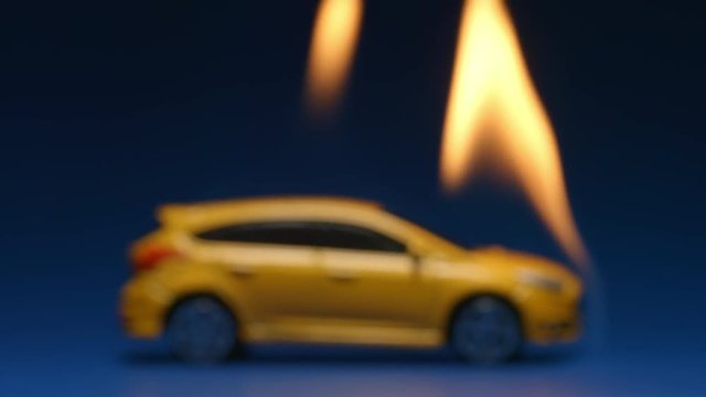 SLOW MOTION: Burning yellow car on a blue background