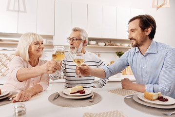 Cheerful man greeting his parents with holiday at home