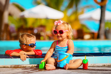 little boy and girl playing in swimming pool at beach