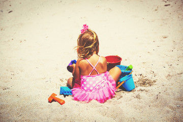 Fototapeta na wymiar cute little girl play with sand on beach