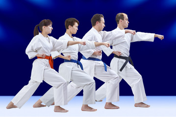 On a dark blue background four adult athletes are beating punch arm