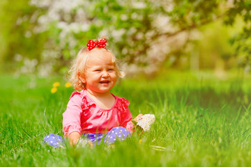 cute little girl with flowers in spring nature