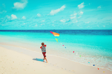 Fototapeta na wymiar Little boy flying a kite on beach