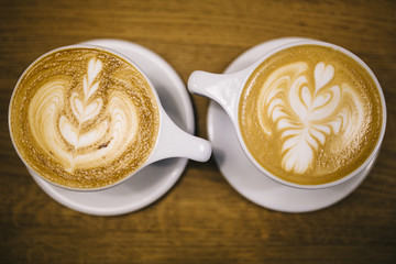 Overview of two Lattes with drawings on a wooden table