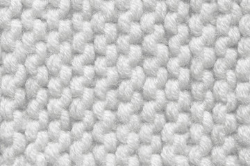 Knitted texture of white color. Hand-made knitting needles for postcard background. Winter cozy thing.