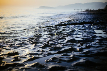 Waves and stone surface closeup of texture on the beach