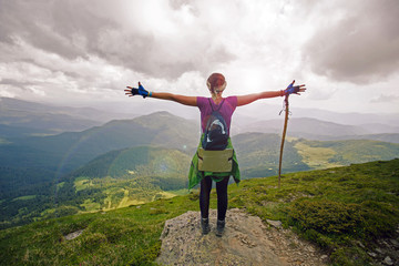 Girl is standing on top of the rock and enjoying the view. A girl on top look on landscape of...