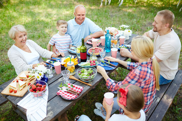 Family of three generations relaxing by dinner during hangout