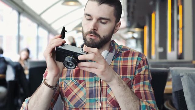 Irritated man having problems with his old, vintage camera, steadycam shot
