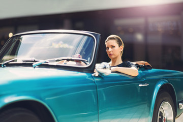 Portrait of beautiful sexy fashion woman model in sunglasses sitting in luxury retro cabriolet car