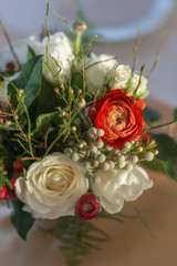 red and ivory floral arrangement prepared for reception, wedding table with candle and setting, winter concept