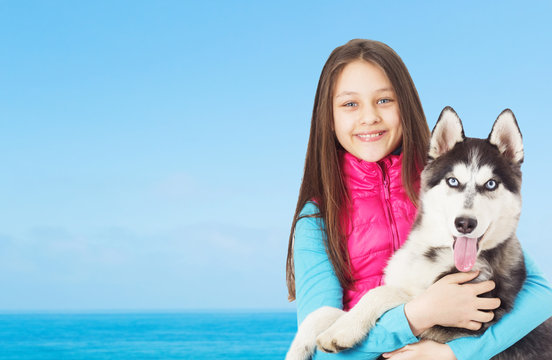 Girl and Siberian husky on background of the sea