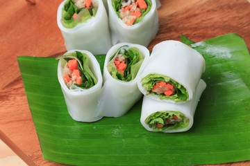 spring roll with vegetable on banana leaf wood floor background , Select focus  shallow depth of field.
