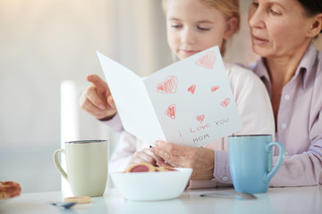 Grandparent and grandchild reading mother day card with regards