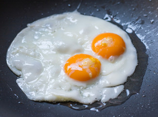two fried eggs in a frying pan