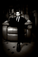 Fototapeta na wymiar Respectable handsome man sits in a leather chair.