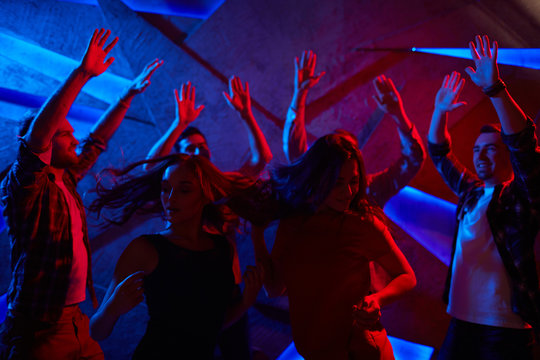 Group of raving dancers enjoying discotheque