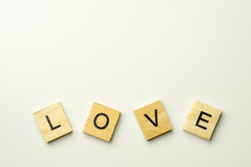 Text wooden blocks spelling the word LOVE on white background