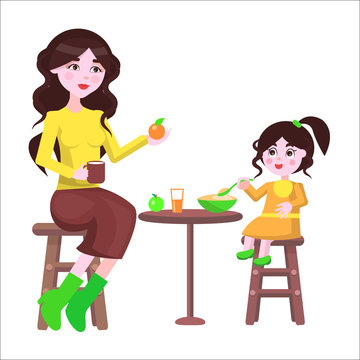 Mother and her Daughter Sit at the Table and Eat