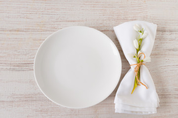 Top view of fresh snowdrops brunch with empty plate