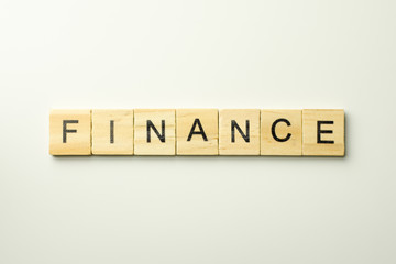 Text wooden blocks spelling the word FINANCE on white background