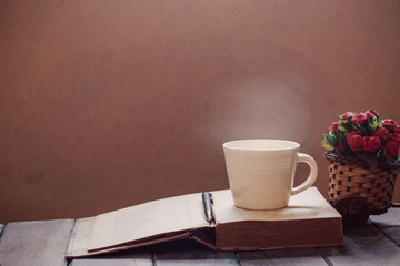 Cup and book on the wooden.