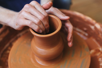 Fototapeta na wymiar Handicraftsman making fireclay jug in pottery-wheel