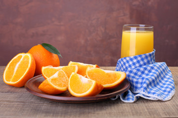 Orange juice in glass with fresh fruits on wooden background