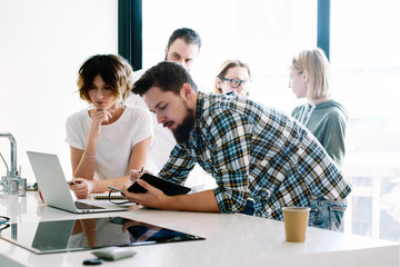 International students are discussing the course they watched online on a laptop. Group of young hipsters is discussing new business ideas during on-line meeting with the partners.