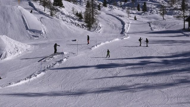 Aerial view of skiers on mountain ski slope skiing downhill and enjoying winter sport activity, drone-like view from cableway chair