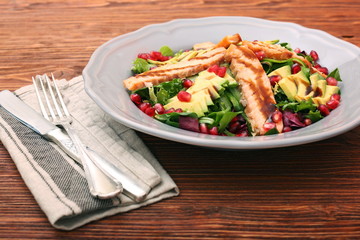 Salad with fried salmon, avocado and pomegranate seeds