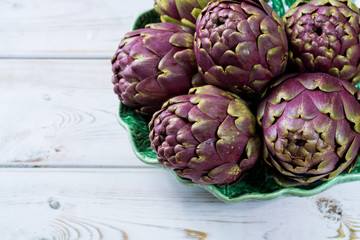 Obraz premium Fresh big Romanesco artichokes green-purple flower heads ready to cook