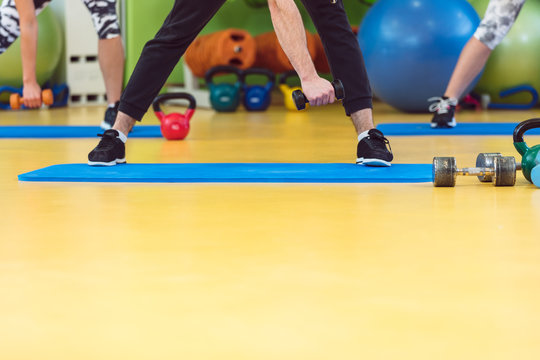 Group Of People Working Out In A Gym With A Dumbbell