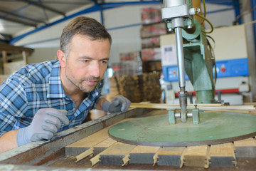 sawmill employee working with wood tools and machinery