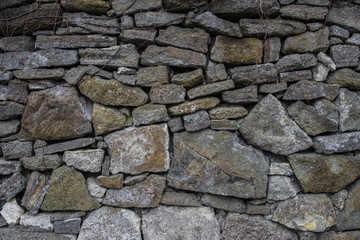 Ancient old dark irregular stone wall