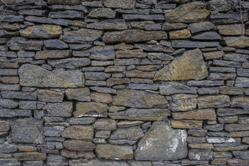 Ancient old dark regular stone wall