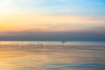 Naklejka premium Boat slow downstream on the water near fence in silhouette.