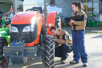 agricultural mechanics checking tractors condition before harvesting - obrazy, fototapety, plakaty