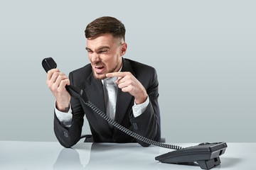 Naklejka premium young man dials the phone number while sitting in the office
