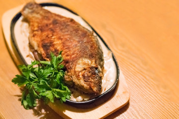 Fried fish with parsley on a plate