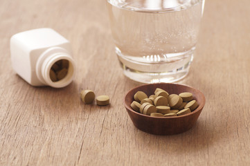 herb medicine in pill on wood table