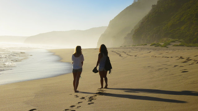Girl girls on Johanna beach, Australia at sunset with waves with beautiful mist from splashing waves