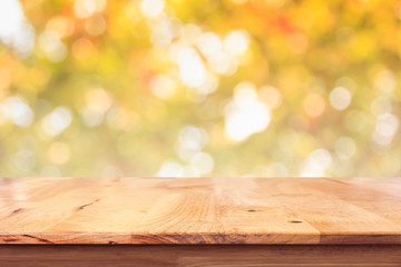 Empty wood table with bokeh yellow background.