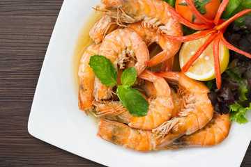 Shrimp boiled with honey and salt in white dish on dark table thai food