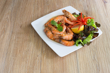 Shrimp boiled with honey and salt in white dish on dark table thai food